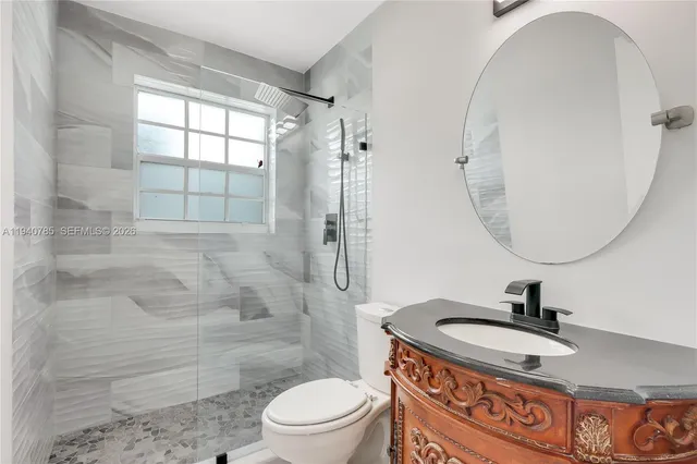 a bathroom with a sink toilet a mirror and shower