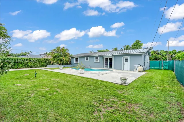 a view of house with swimming pool and yard