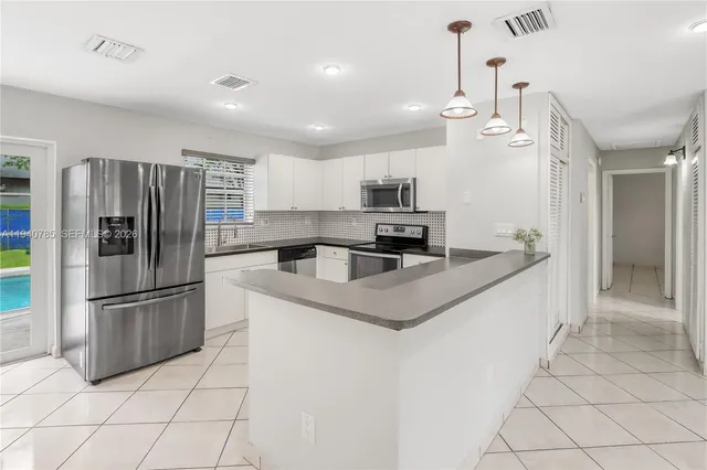 a kitchen with granite countertop a refrigerator and a sink