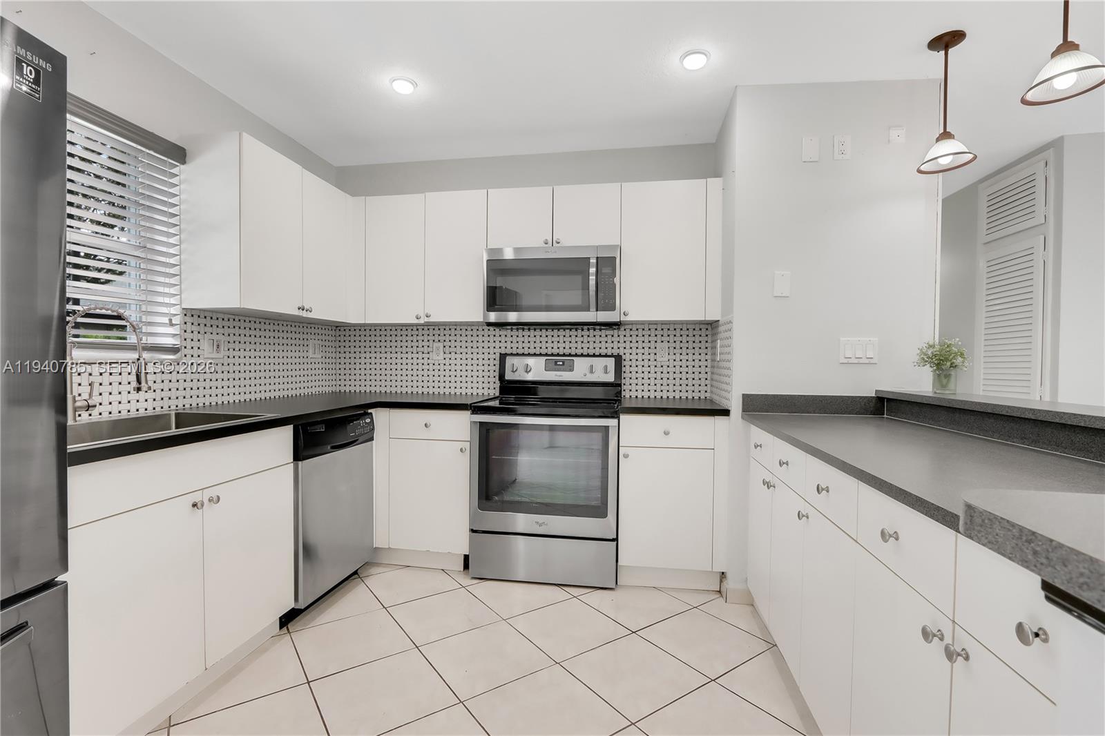5725 Southwest 107th Place Miami, FL 33173 - Photo 10 of 21 a kitchen with granite countertop white cabinets and stainless steel appliances