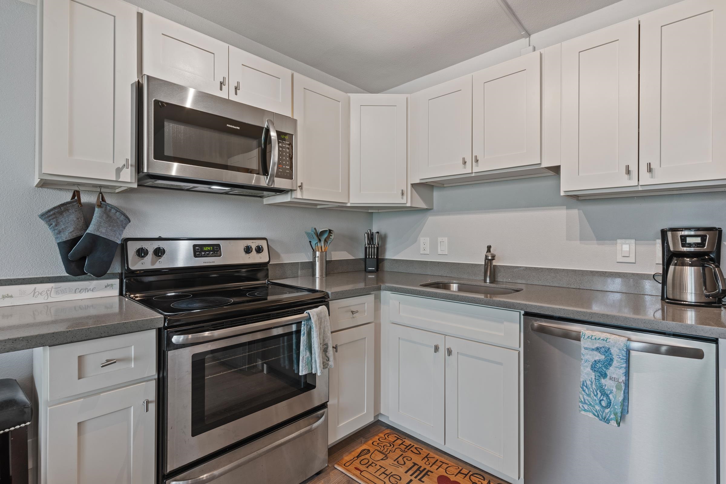 2495 South Kihei Road, Unit 155 Kihei, HI 96753 - Photo 19 of 33 a kitchen with granite countertop white cabinets sink and stainless steel appliances