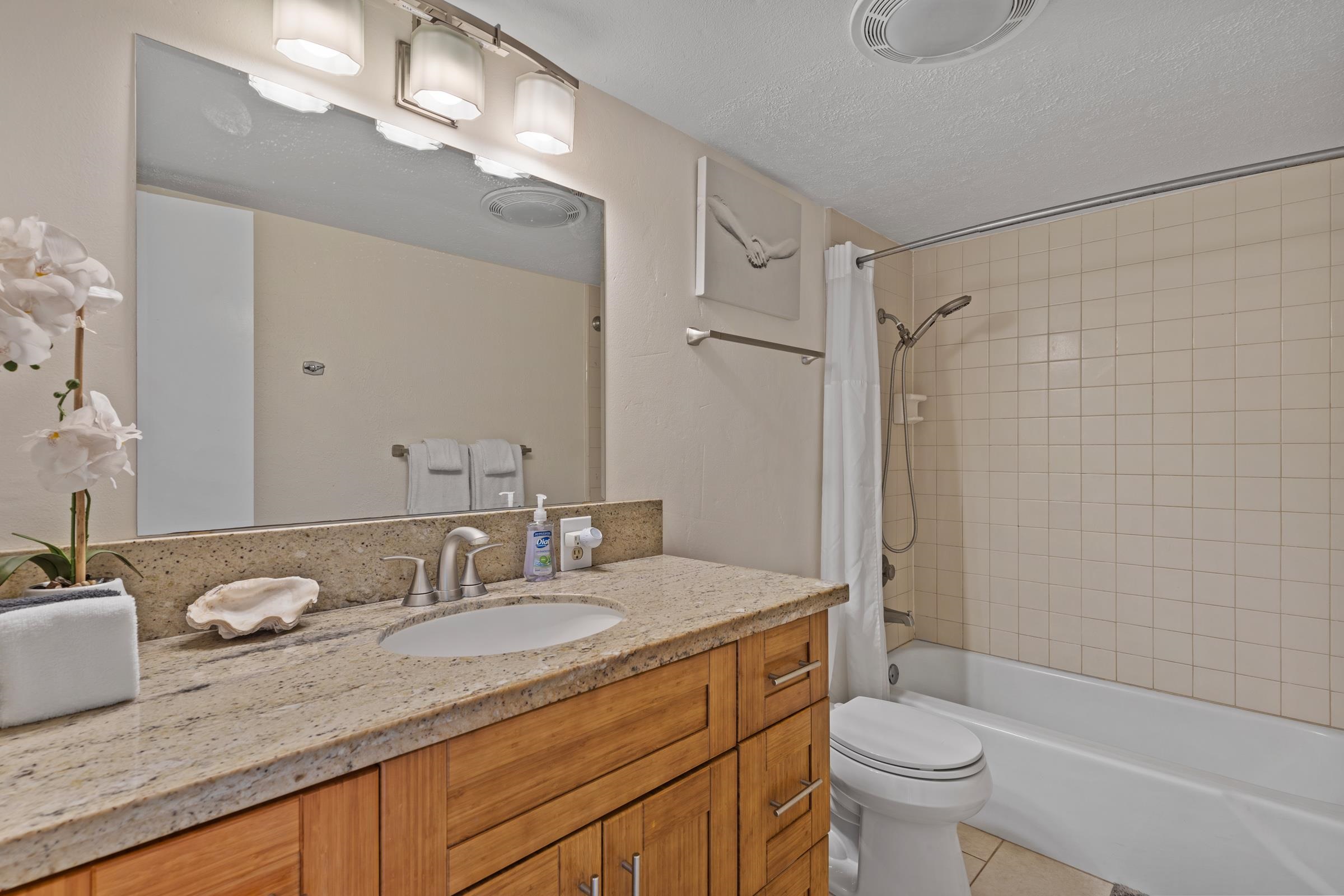 2495 South Kihei Road, Unit 155 Kihei, HI 96753 - Photo 31 of 33 a bathroom with a double vanity sink toilet mirror and shower