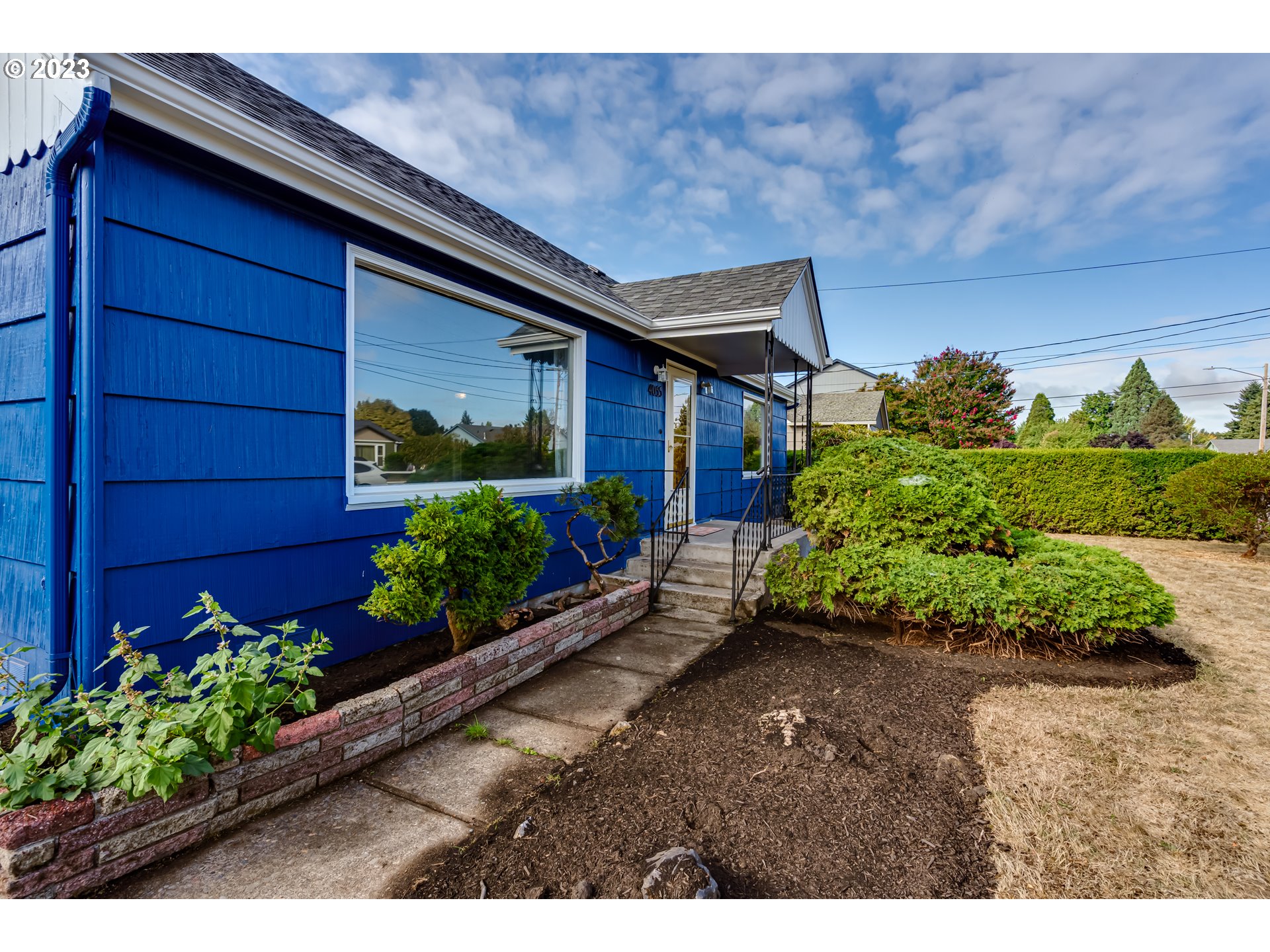 4055 North Street Springfield, OR 97478 - Photo 3 of 48 a house with a lot of flower plants in front of main door