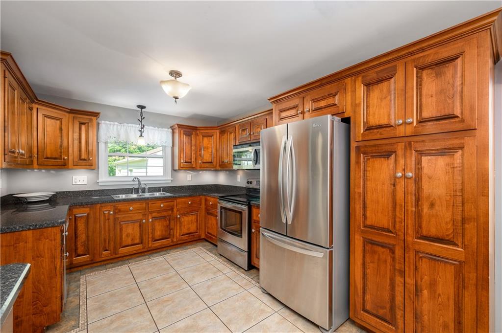 939 Fredonia Road Hadley, PA 16130 - Photo 14 of 36 a kitchen with granite countertop stainless steel appliances a refrigerator stove top oven and sink