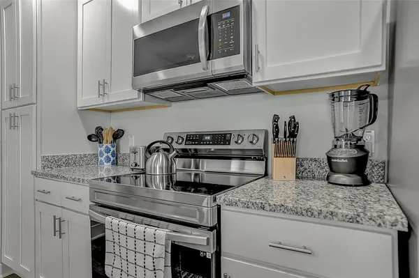 a kitchen with granite countertop a sink and cabinets
