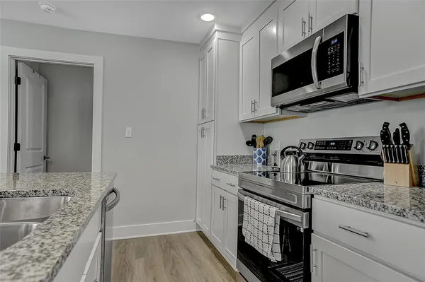 a kitchen with stainless steel appliances granite countertop a sink stove and microwave