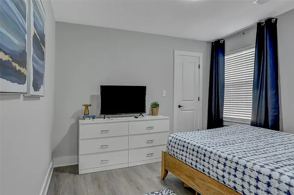 a bedroom with a bed and a flat screen tv