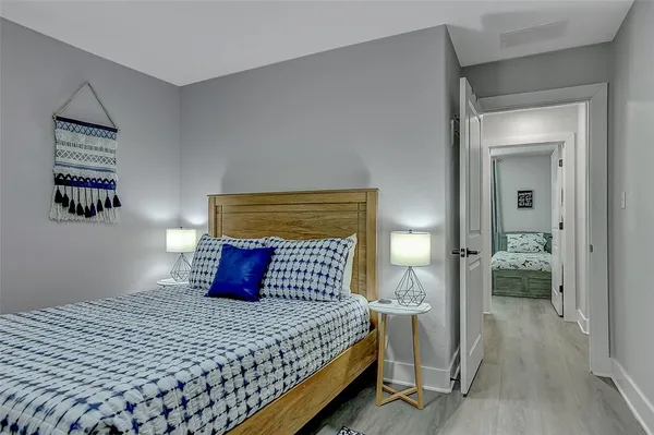 a bedroom with a bed and wooden floor