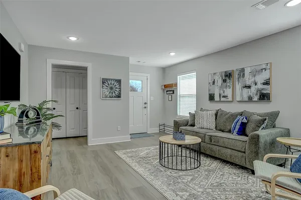 a living room with furniture and wooden floor