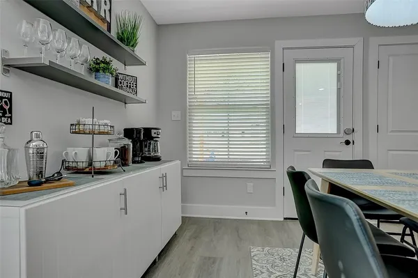 a kitchen with stainless steel appliances a sink a stove a window cabinets and a dining table