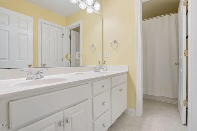 a bathroom with a double vanity sink and a mirror