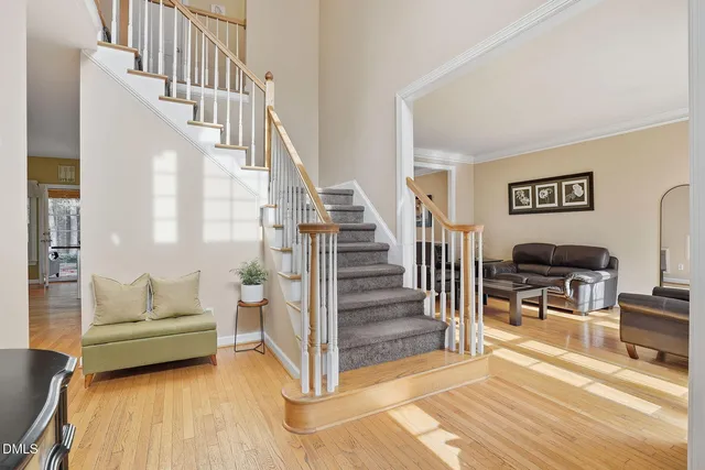 a living room with wooden floor and a dining table