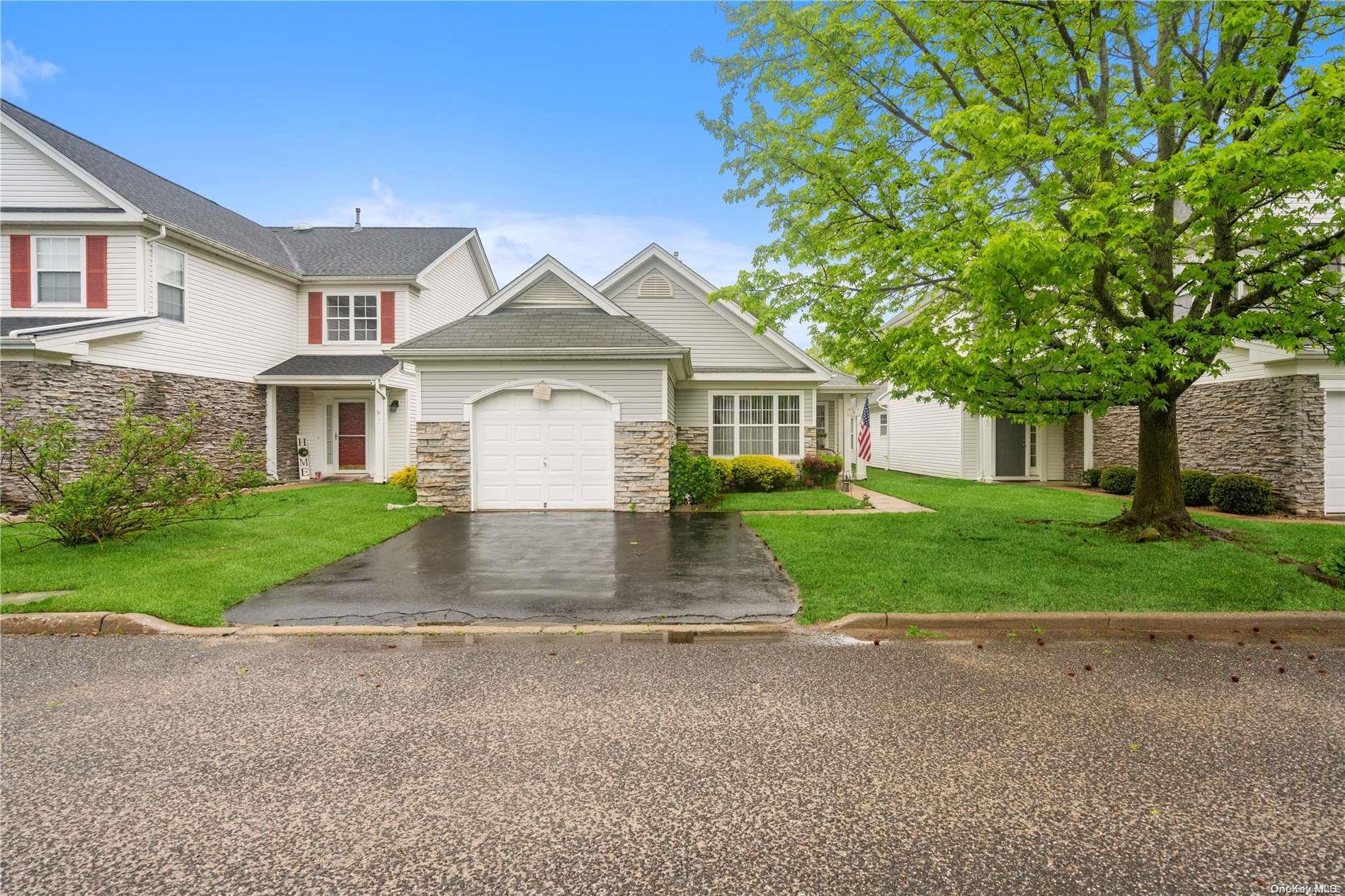 a front view of a house with a yard and trees