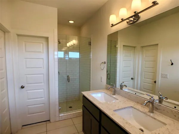 a bathroom with a granite countertop sink shower and a mirror