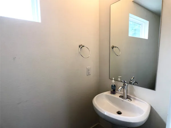 a bathroom with a sink a light fixture and a mirror