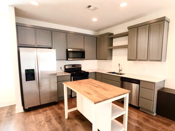 a kitchen with a sink a microwave a refrigerator and cabinets