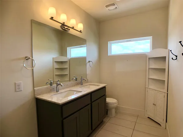 a bathroom with a sink a toilet and mirror