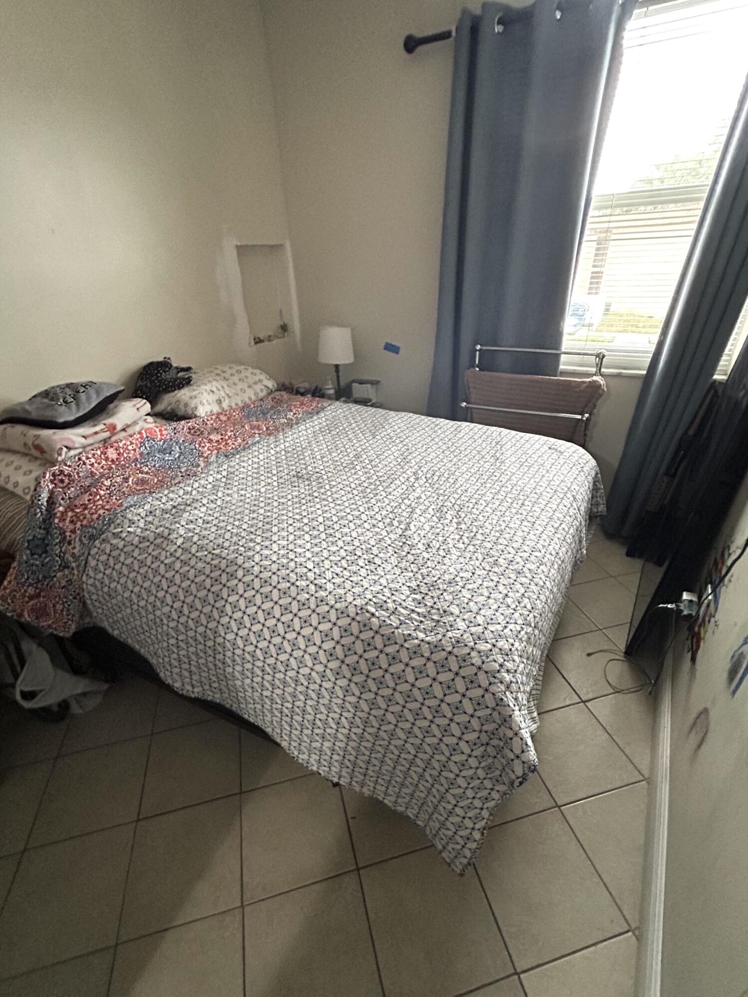 506 Davis Road, Unit 66 Palm Springs, FL 33461 - Photo 15 of 26 a bed sitting in a bedroom next to a window