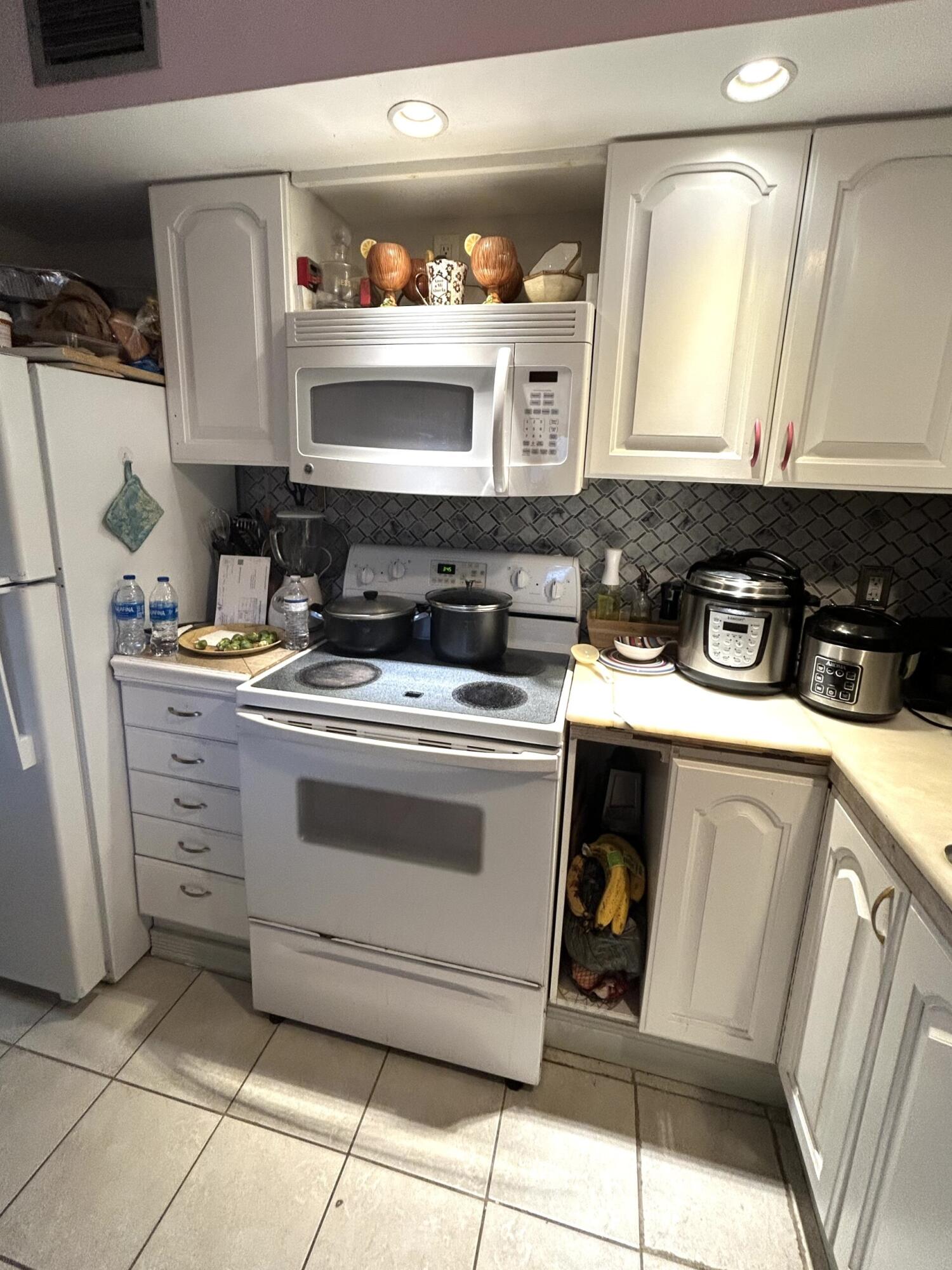 506 Davis Road, Unit 66 Palm Springs, FL 33461 - Photo 19 of 26 a kitchen with a stove and a sink