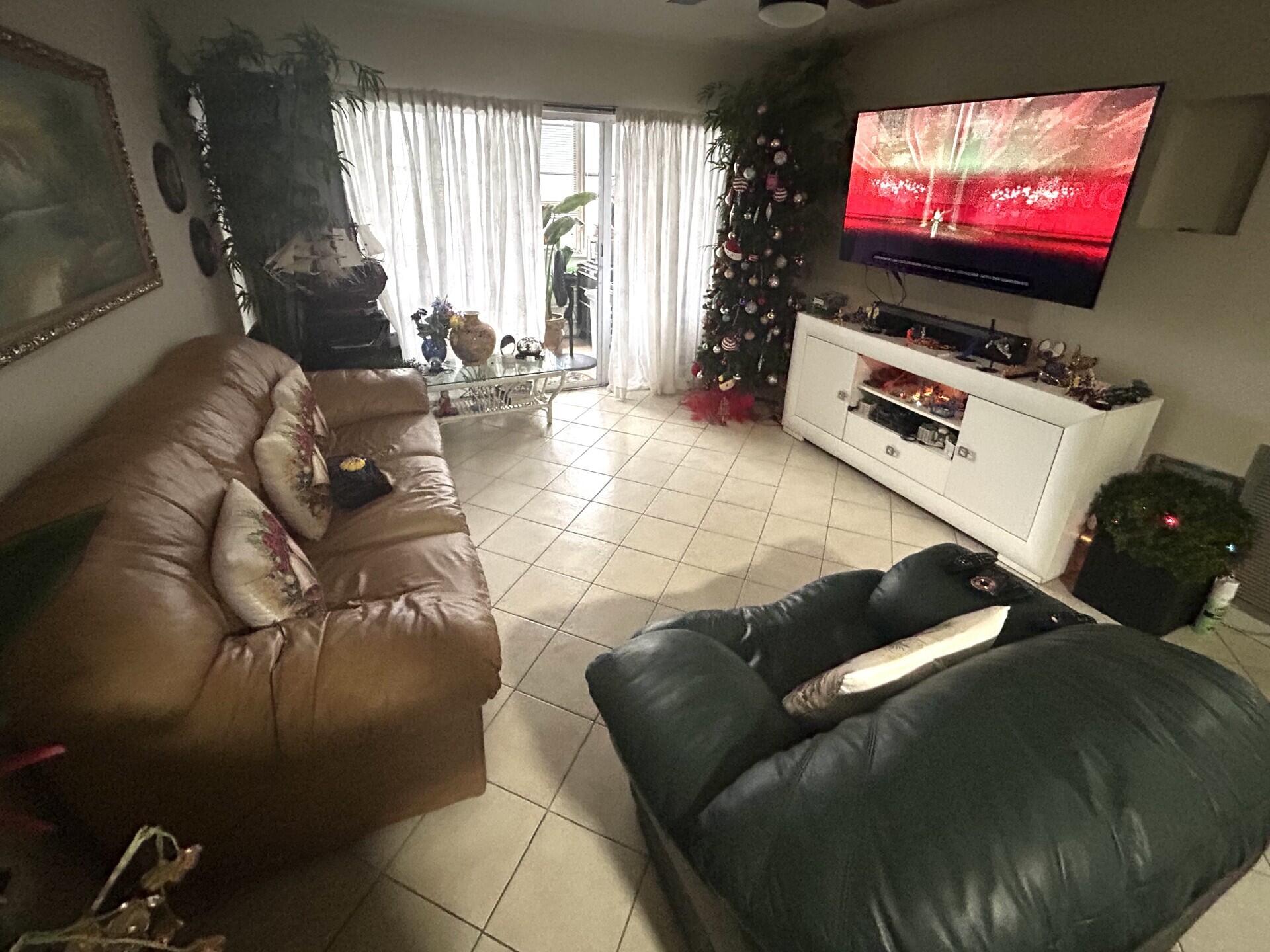 506 Davis Road, Unit 66 Palm Springs, FL 33461 - Photo 4 of 26 a living room with furniture and a flat screen tv