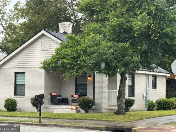 a front view of a house with garden and plants
