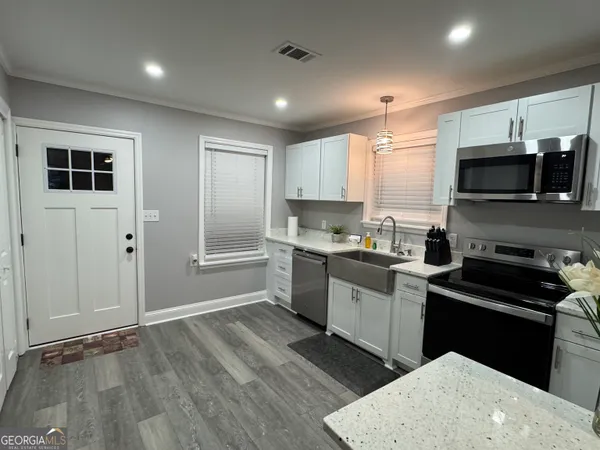 a kitchen with a sink a microwave and cabinets