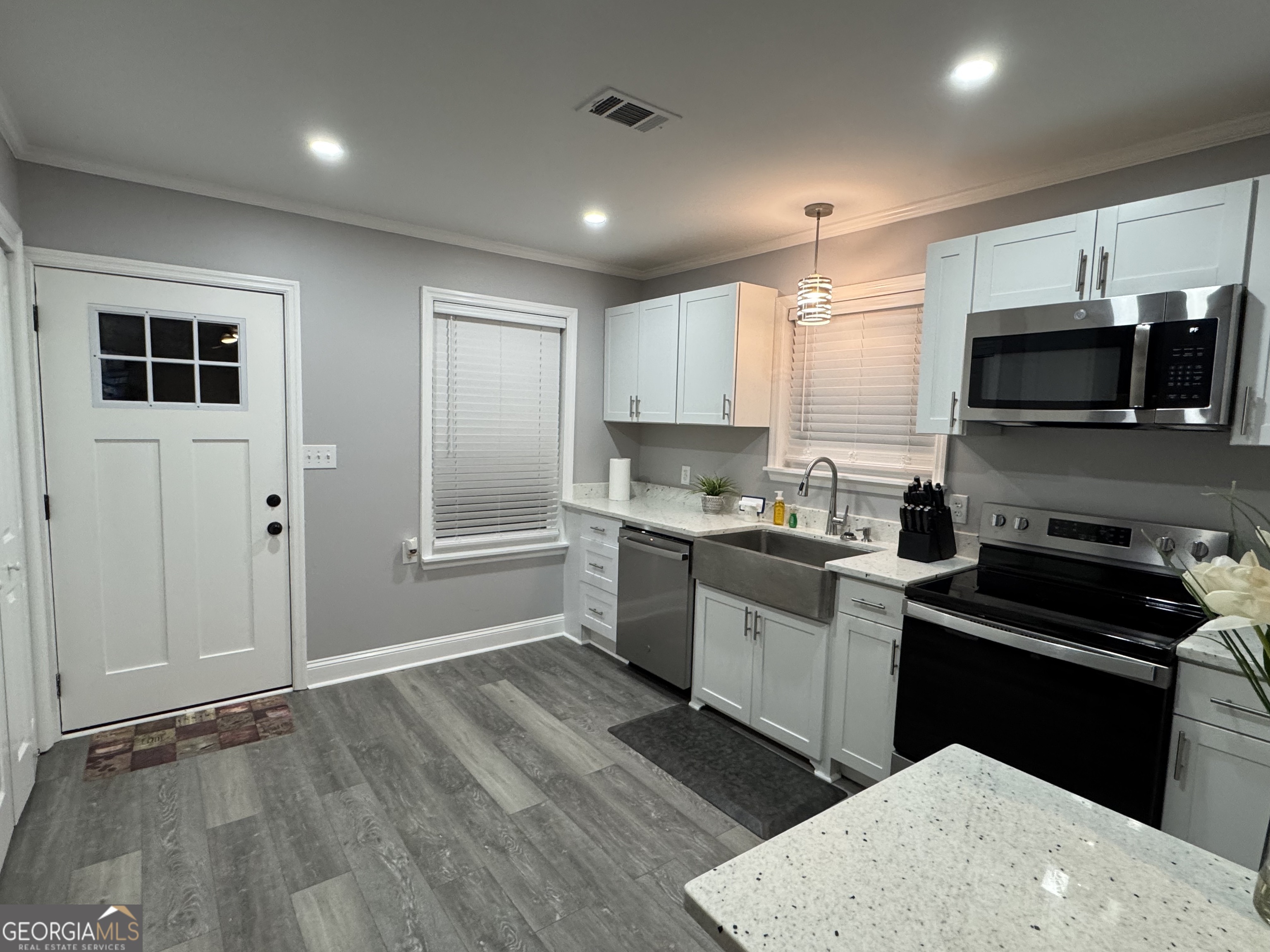 339 North Gray Street Millen, GA 30442 - Photo 6 of 16 a kitchen with a sink a microwave and cabinets