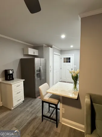 a living room with furniture and a refrigerator