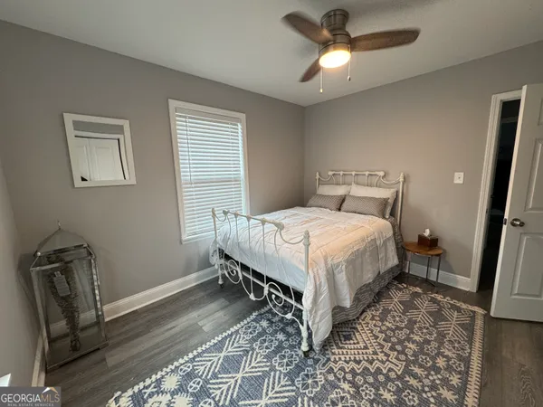 a bedroom with a bed window and a chair