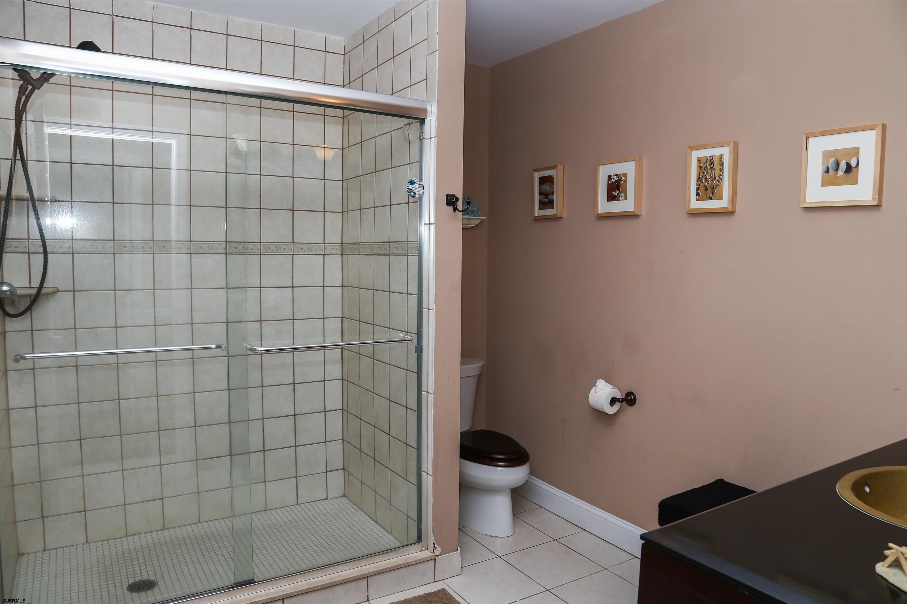 4818 Harbor Beach Boulevard Brigantine, NJ 08203 - Photo 22 of 30 a bathroom with a toilet and a shower