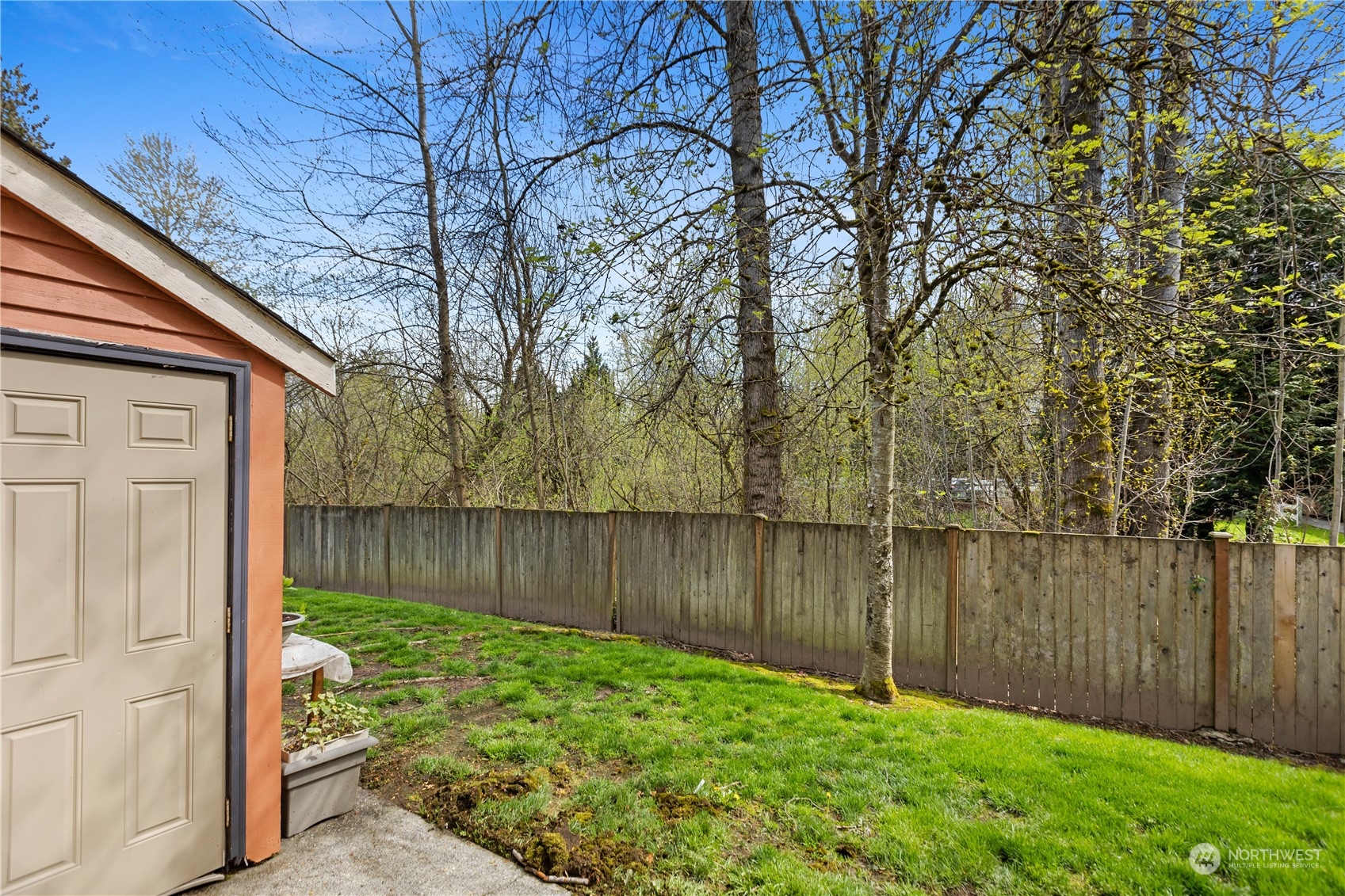 412 Center Road, Unit E2 Everett, WA 98204 - Photo 16 of 18 a backyard of a house with lake view and wooden fence
