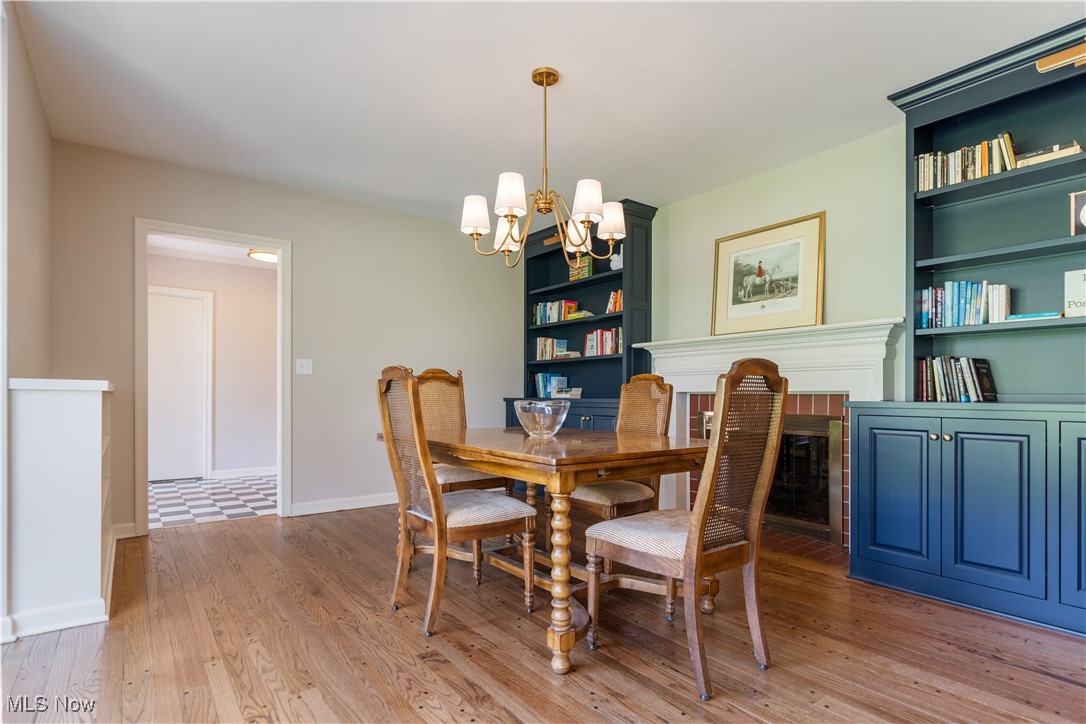 2622 Glenmont Road Northwest Canton, OH 44708 - Photo 7 of 45 Dining room featuring baseboards, wood finished floors, built in shelves, and an inviting chandelier