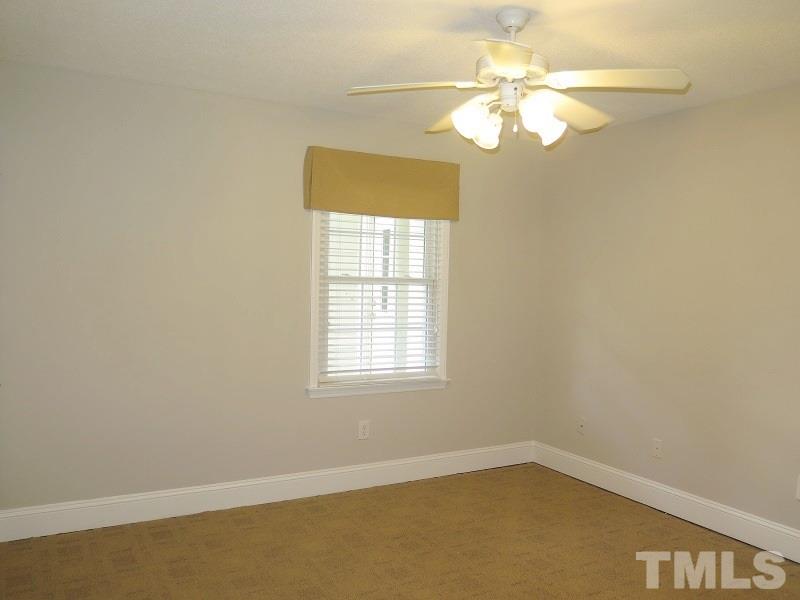 7617 Harps Mill Road Raleigh, NC 27615 - Photo 12 of 24 an empty room with a chandelier fan and windows