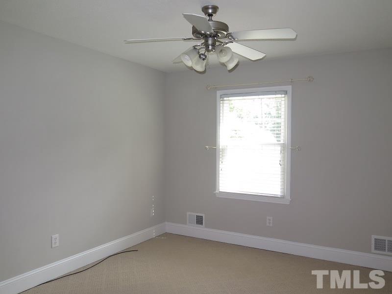 7617 Harps Mill Road Raleigh, NC 27615 - Photo 13 of 24 an empty room with a window and a fan