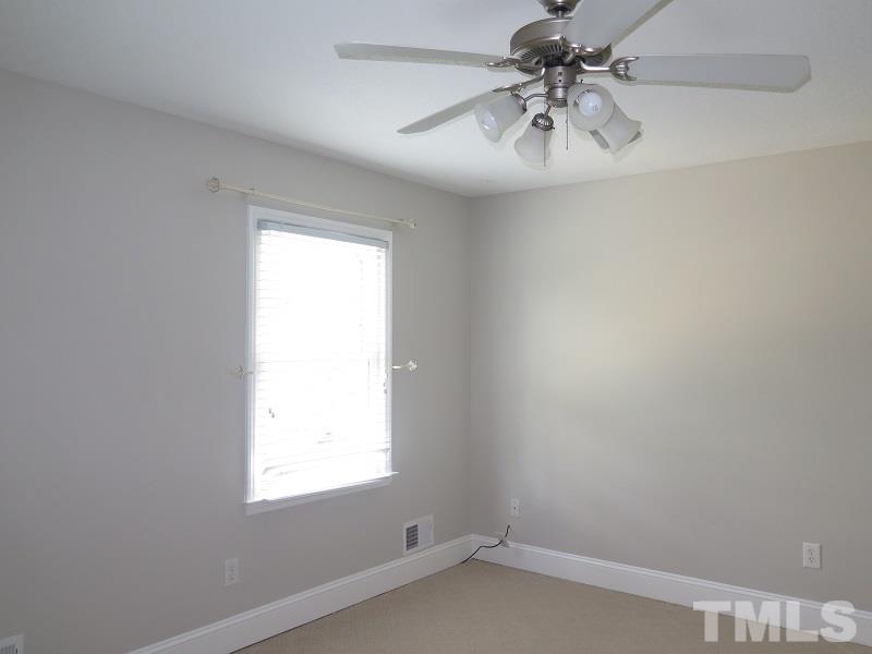 7617 Harps Mill Road Raleigh, NC 27615 - Photo 14 of 24 an empty room with a window and a ceiling fan
