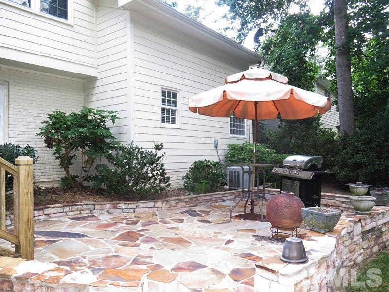 7617 Harps Mill Road Raleigh, NC 27615 - Photo 20 of 24 a view of a table and chairs under an umbrella