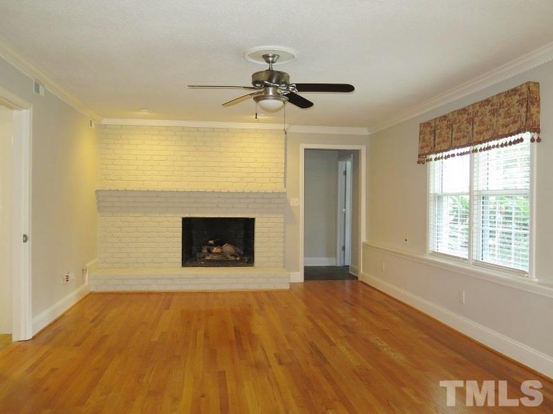 7617 Harps Mill Road Raleigh, NC 27615 - Photo 4 of 24 a view of an empty room with a fireplace and a window
