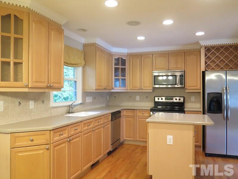 7617 Harps Mill Road Raleigh, NC 27615 - Photo 6 of 24 a kitchen with stainless steel appliances granite countertop a sink a stove a refrigerator cabinets and a counter top space