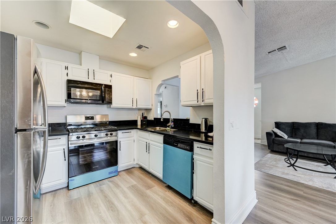 1751 East Reno Avenue, Unit 228 Las Vegas, NV 89119 - Photo 13 of 39 Culinary delights await in this bright kitchen, showcasing modern appliances and seamless transitions to living spaces.