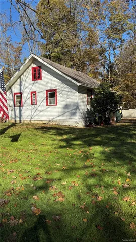 a view of a yard in front of a house with large trees