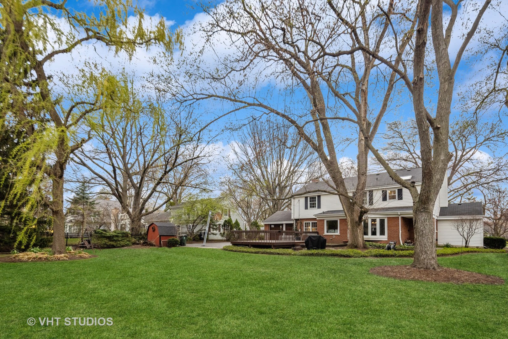 1200 Woodview Road Burr Ridge, IL 60527 - Photo 3 of 22 a front view of a house with a garden and trees