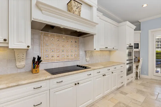 a kitchen with granite countertop a sink a stove and cabinets