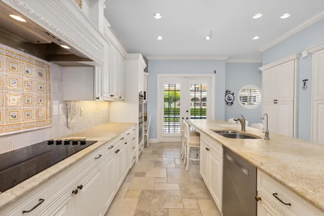 a large kitchen with granite countertop a sink and cabinets