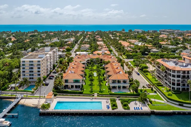 an aerial view of ocean and residential houses with outdoor space