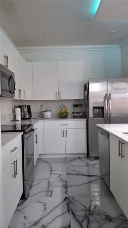 a kitchen with granite countertop a sink a stove and cabinets