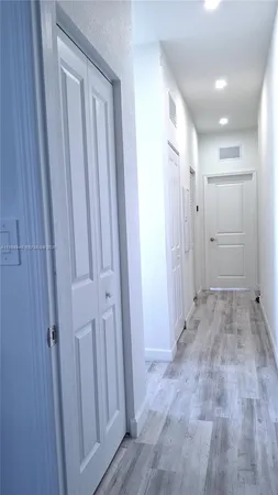 a view of a hallway with wooden shelves