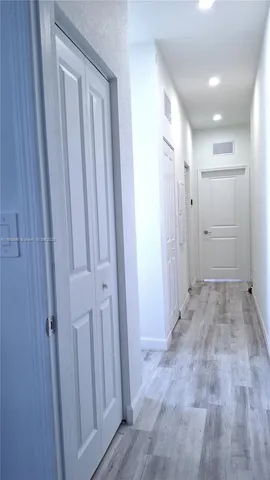 a view of a hallway with wooden shelves
