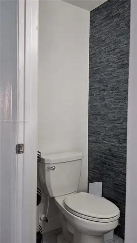 a white toilet sitting next to a shower