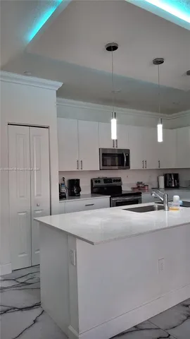 a kitchen with kitchen island a sink stainless steel appliances and cabinets
