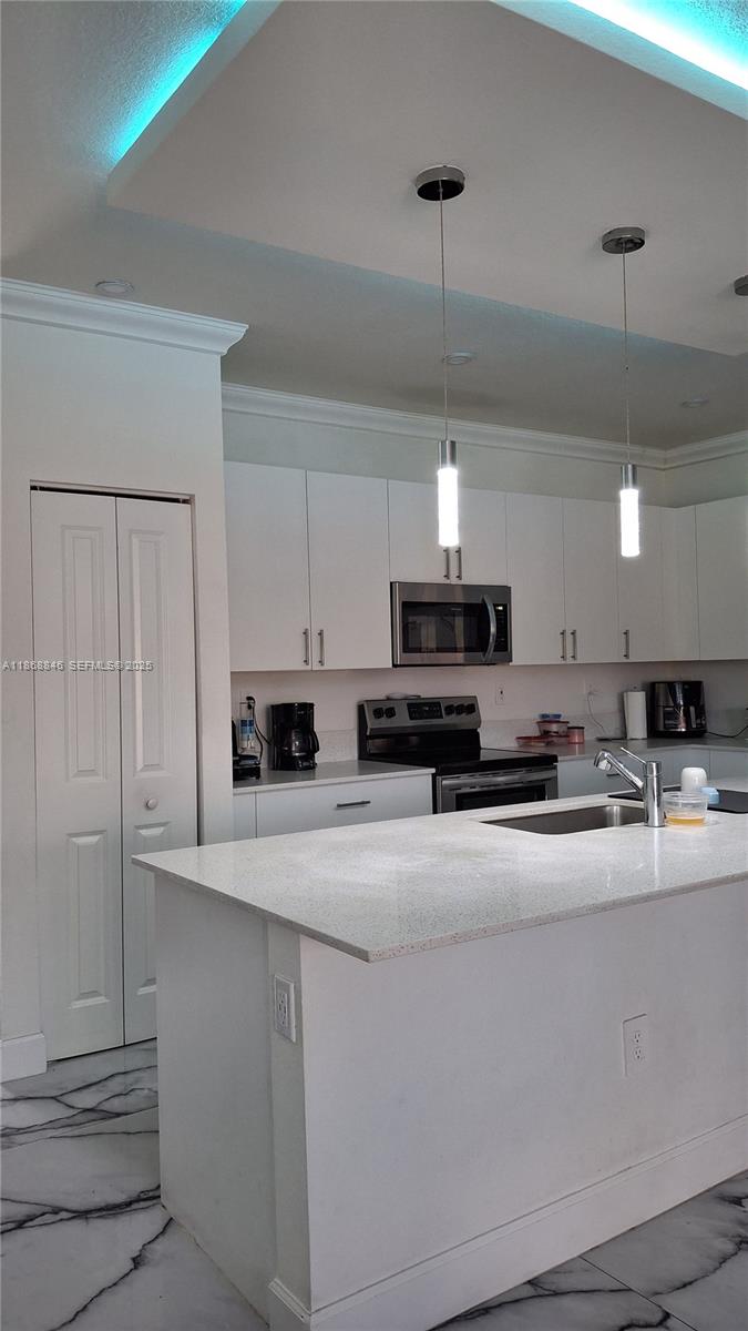 26410 Southwest 148th Court Homestead, FL 33032 - Photo 10 of 42 a kitchen with kitchen island a sink stainless steel appliances and cabinets